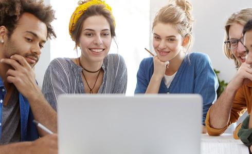 group of students looking at a laptop