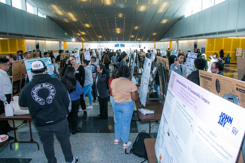 students gathered around research presentation boards